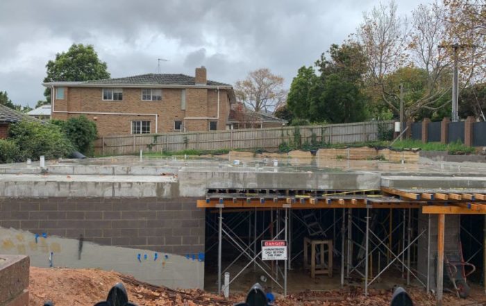 Residential concrete slab with orange and black timber formwork demonstrating temporary support and structural design